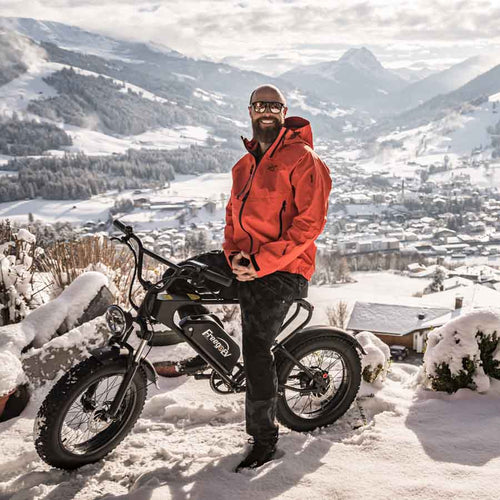 Freego DK200 fat tire e-bike with rider standing in a snowy mountain town