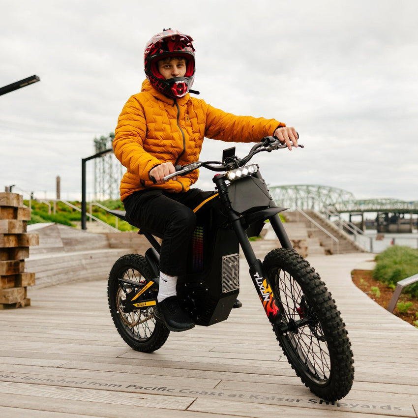 Freego Nova 4 electric dirt bike rider on a boardwalk by a bridge