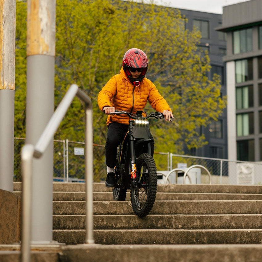 Freego Nova 4 electric dirt bike rider descending outdoor steps