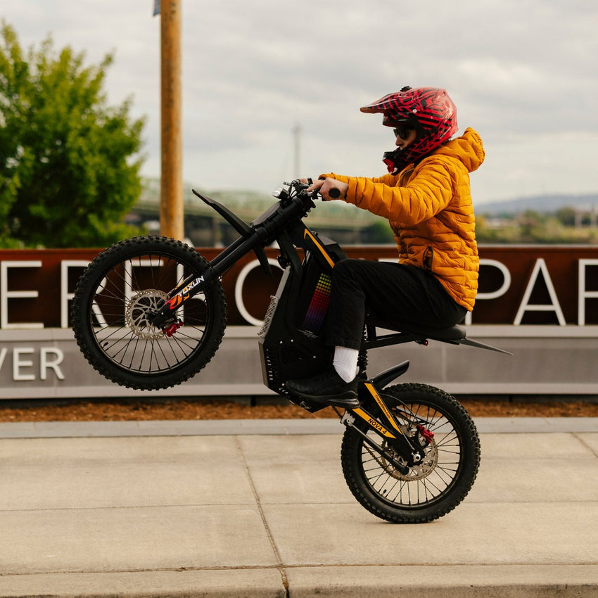 Freego Nova 4 electric dirt bike wheelie on a paved plaza