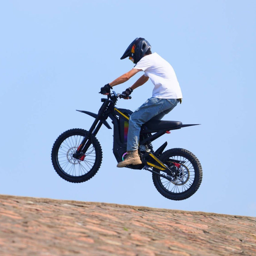 Freego Nova 4 electric dirt bike rider cresting a dirt hill