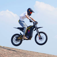 Freego Nova 4 electric dirt bike jumping off a dirt ridge