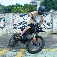 Freego Nova 4 electric dirt bike riding past a graffiti wall