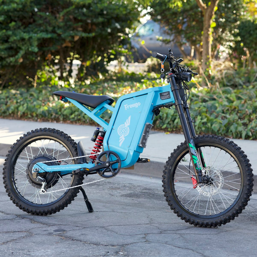 Freego X2 Pro Blue Limited electric dirt bike parked on pavement with green hedges behind